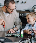 Father and son using Pro Grade Aluminum Soldering Flux Liquid for Quick Dry Welds, colorless stainless steel flux paste on electronics.