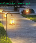 Lit Flickering Flame Solar Lanterns Set Metal Outdoor Hanging Lights Waterproof LED Flame Lamps illuminating a garden path