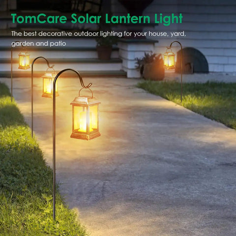 Lit Flickering Flame Solar Lanterns Set Metal Outdoor Hanging Lights Waterproof LED Flame Lamps illuminating a garden path