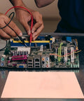 Person working on Single Sided Copper Clad PCB Laminate 1.4mm Thick Copper Plated Universal Circuit Board For Etching And DIY Prototyping Kit 20x30cm And 11.8x7.8 Inches For Easy Soldering And Circuit Projects on a workbench.
