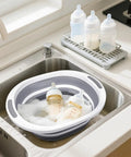 Collapsible Wash Basin 7.5L Dish Tub Sink Basin Folding Dish Pan With 2-In-1 Dish Pan And Cutting Board with baby bottles in sink