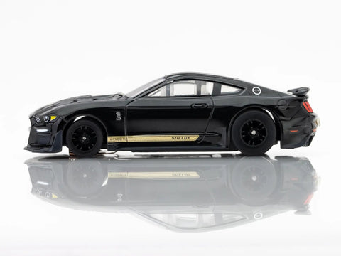 Side view of Ford Shelby Mustang GT500H Mega G Plus HO Slot Car Black And Gold King Of The Road Edition on reflective surface.