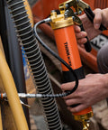 ThinkWork 8000 PSI orange grease gun with brass fittings, pistol grip, and black hose in side view.