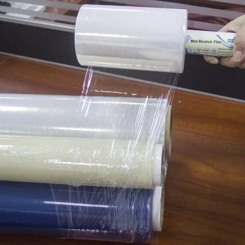 Top Shelf Clear Stretch Wrap 6 Inch By 1000 Feet Plastic Roll for Moving and Shipping Heavy Duty Shrink Film on a wooden table.