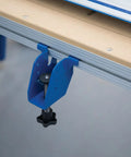 Close-up of blue adaptive cutting system extension bracket bolted onto a workbench for easy setup. Level Up Your Shop Rig With These Knockout Adaptive Cutting System Extension Brackets That Bolt Right Onto Standard Workbenches Or Portable Project Tables For Quick Setup.