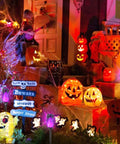 Purple Solar Tiki Torches Outdoor Lights 12 Pack With Flickering Flame illuminating Halloween decor with pumpkins