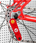 Close-up view of bike chain and red part with spider logo on a Single Speed Freewheel For Mountain Bikes 12T Gear Sprocket Beefy Steel Construction Easy Index Shifting Smooth Ride Durable Replacement Freewheel Part For Upgrading Your Mountain Bike.