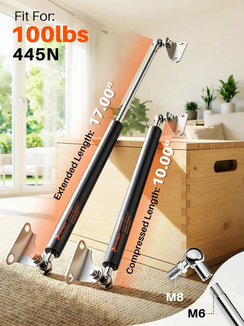 Heavy Duty 17 Inch Gas Struts Twin Pack With L Type Mounts, 100 Lb Capacity near a wooden box in a living room setting.