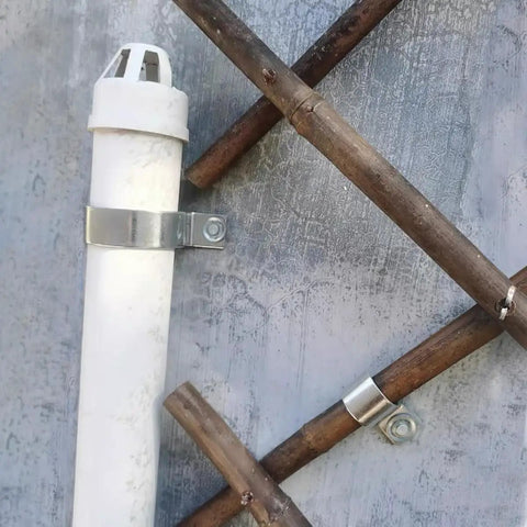 304 Stainless Steel Conduit Pipe Clamps Mounting Brackets One-Hole P-Type Clips securing a white pipe on wooden beams