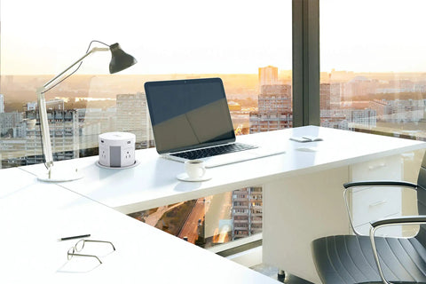 Slick Pop Up Countertop Outlet With Hidden Recessed Design, Wireless Charger Pad on an office desk setup with laptop and lamp.