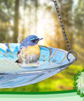 11 Inch Hanging Glass Bird Bath With Peacock Pattern Outdoor Bird Feeder And Garden Decor For Yard Bright Colorful Wavy Rim That Attracts Birds And Elevates Your Outdoor Space showing a bird bathing in a blue glass bowl with iron chain.