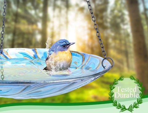 11 Inch Hanging Glass Bird Bath With Peacock Pattern Outdoor Bird Feeder And Garden Decor For Yard Bright Colorful Wavy Rim That Attracts Birds And Elevates Your Outdoor Space showing a bird bathing in a blue glass bowl with iron chain.