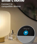 Dope Wireless Smart Alarm Clock With Sleek Build And Thumping Bass Solid For Nightstands Or Kitchens Checks Weather Streams Tracks Manages Connected Devices Glossy Black beside a lamp.