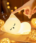 Children's room lit by Kids Night Light Puppy Lamp With Remote And 16 Color Modes, soft glow, touching lamp on table, cute decor.