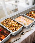 4 Pack Full Size Hotel Pans 1/1 Deep 4 Inch Heavy Duty Stainless Steel Food Pans holding various buffet dishes.