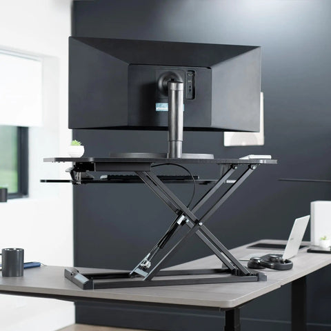 Extra Wide 38 Inch Corner Desk Converter With Height Adjustable Sit To Stand Riser For Dual Monitor And Laptop Setup Large 38 Inch Surface And Wide Keyboard Tray Black, shown in office setting with single monitor