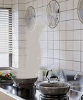 Heavy Hitter Industrial Turbine Fan That Goes Hard With Top Notch Ventilation And A Smooth Exhaust Setup Featuring Six Blades For Wide Angle Cooling Across Workshops And Garages On Standard Residential Voltage in a kitchen with square tiles and steam rising from pans.