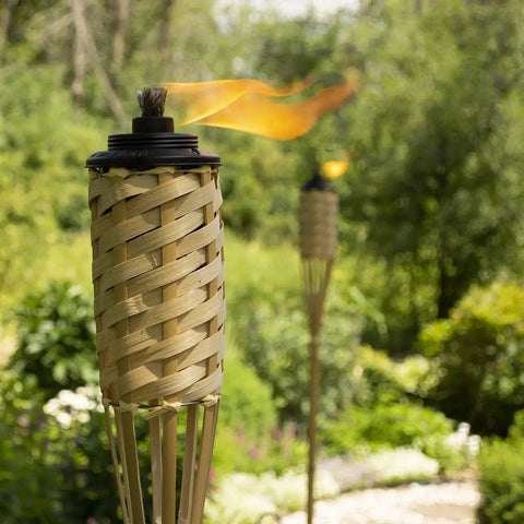 Twelve Pack Bamboo Torches For Patio And Backyard 57 Inch Tall Weather Resistant Citronella Torches in garden setting