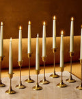 Flameless Taper Candles Set With Realistic 3D Flame And Wick, 9-Inch Ivory Wax LED Candles, 10 Pack on gold holders, ambient lighting