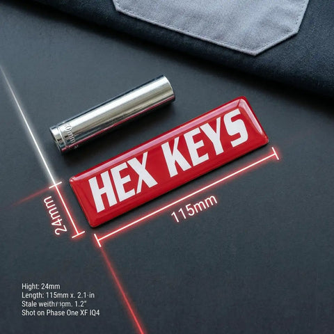 Close-up of red magnetic label for 'HEX KEYS', part of 35 Pack Magnetic Toolbox Labels Set For Tool Chests And Drawers, 3mm Thick DuraGloss Epoxy Tags, Oil Resistant Red Mechanic Labels For Steel Carts And Cabinets, Pro Grade Grippy Organization For Shop Garage And Workbench