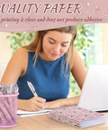 Woman writing with Floral Rose Pink Pen And Notepad Gift Set With 12 Flower Ballpoint Pens And 12 Pretty Notepads beside laptop