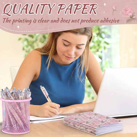 Woman writing with Floral Rose Pink Pen And Notepad Gift Set With 12 Flower Ballpoint Pens And 12 Pretty Notepads beside laptop