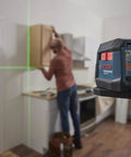 GLL50-20G 50 Ft Green-Beam Self-Leveling Cross-Line Laser With Integrated Magnetic Mount in use on kitchen cabinet installation