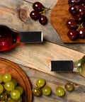 Wine Heat Shrink Capsules Set 100 Pieces With PVC Bottle Sealing Film on two wine bottles with grapes on wooden table