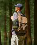Person in forest with backpack, carrying Bug Free Camping Hammock With Mosquito Net, Ultralight Portable Outdoor Hammock for camping.