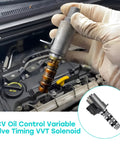 Hand holding VVT solenoid beside engine bay; 2 Pack VVT Variable Valve Timing Solenoid For 3.5L V6 Engines, Oil Control Valve Replacement Set Direct Fit