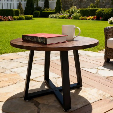 Outdoor setting with a round wooden table featuring industrial black metal table legs set 28 inch high 24 inch wide.