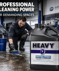 Heavy Lifter Industrial Degreaser Concentrate in use for cleaning shop floors, 128 oz bottle, scrubbing grease and grime.