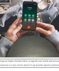 Person using phone covered with Faraday Shield Fabric For EMF Protection That Blocks WiFi RF GPS And RFID Signals With Copper Nickel Polyester Blend.