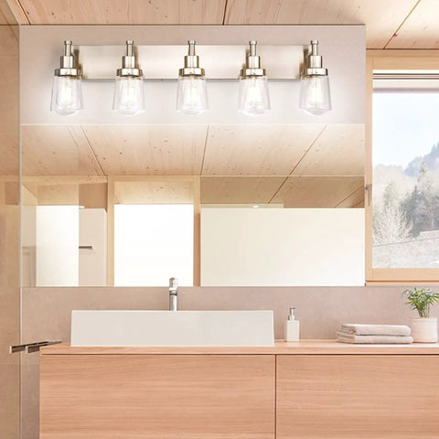 Five Light Brushed Nickel Vanity Light Fixture With Clear Glass Shade Over Mirror For Bathroom, showcasing modern design