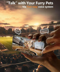 Person using a smartphone to communicate with a cat via two-way audio system in a cozy setting.