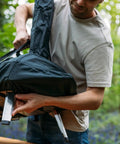 Person lifting Karu 12 And Karu 2 Carry Cover Waterproof Weatherproof Shield For Pizza Ovens, showing lightweight and easy handling.