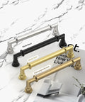 4 kitchen cabinet handles in brushed satin nickel, matte black, matte gold, and champagne bronze finishes on a marble surface.