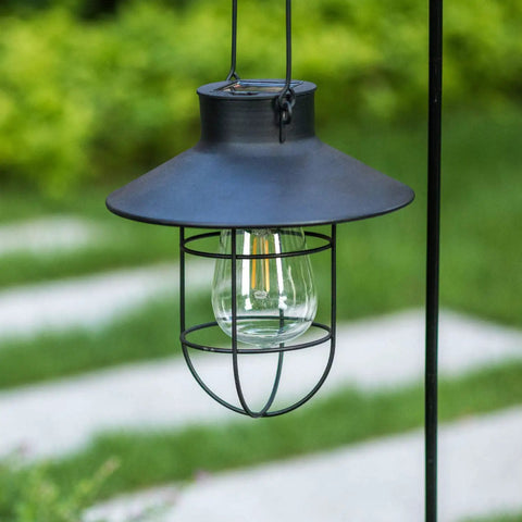 Close-up of one black iron solar lantern from Two Pack Hanging Solar Lantern Lights With Shepherd Hooks Weatherproof Iron Edison Bulb Garden Pathway Lights for Outdoor Patio Lawn Black Finish for All Weather Use