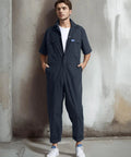 Men's Short Sleeve Coveralls For The Daily Grind, Lightweight Twill Mechanic Jumpsuit With Cargo Pockets, displayed on a model standing against a wall.