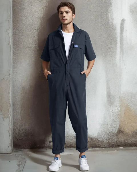 Men's Short Sleeve Coveralls For The Daily Grind, Lightweight Twill Mechanic Jumpsuit With Cargo Pockets, displayed on a model standing against a wall.