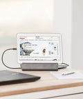 Kickstart Your Workspace Game With This Solid Three Outlet Power Strip And Dual Usb Charging Station Features Sturdy Tablet Cradle with tablet and laptop on a desk.