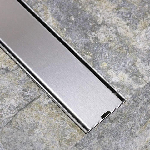 Solid Stainless Steel Floor Drain Catcher With Built In Hair Trap For Showers And Sinks Gravity Drainage Keeps Pipes Clear Zero Drama Cleanup Smooth Rectangular Sink Plug Cover on stone surface.