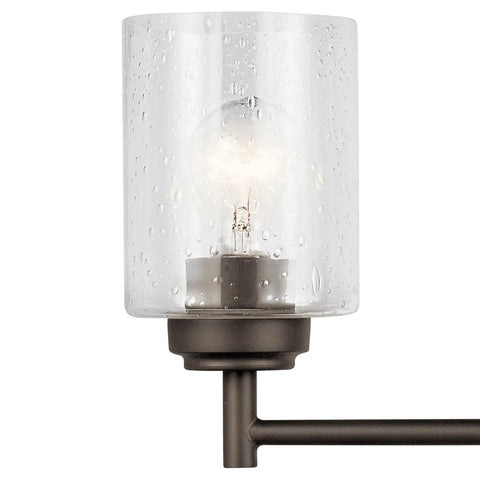 Close-up of Four Light Vanity Light in Olde Bronze with clear seeded glass, transitional style, for above bathroom mirror.