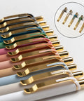 Gold 12 Pack Retractable Ballpoint Pens With Ultra Soft Grip 1.0mm Point Smooth Black Ink For Effortless Everyday Writing Comfortable Non Slip Grip For Men And Women arranged in a row with gold accents