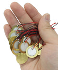 Hand holding 20 Pack 20mm Piezo Discs with Leads for Drum Triggers Guitar Pickup and Microphone Transducer Pre Wired