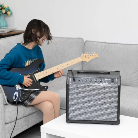 Person playing guitar next to 40 Watt Portable Electric Guitar Amplifier With 8 Inch Speaker And Headphone Jack Aux Input on table