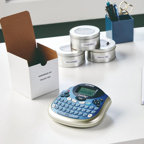 Portable Handheld Label Maker With QWERTY Keyboard And 2 Line Printing on desk next to labeled tea tins and box