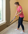 Woman using EZ Roller With Long Reach Handle Holds 22 Oz In The Handle Inner Fed Paint Roller Cuts Mess And Paints Interior Walls