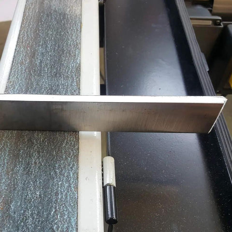 Rugged 4x48 Inch Industrial Belt Grinder With 76 Fps Belt Speed And Rock Hard 2hp Motor showing smooth metal edge being ground.