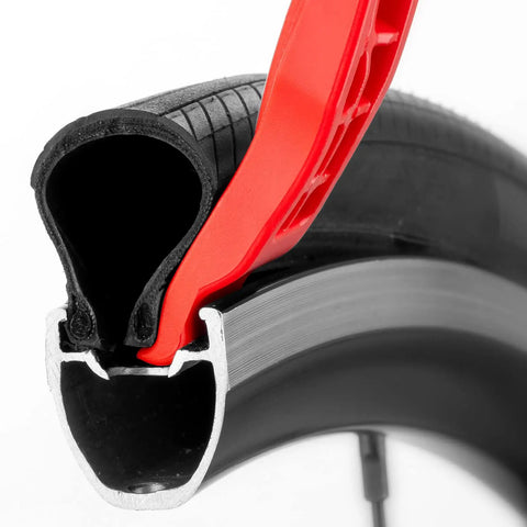 Red lever from Three Pack Bicycle Tire Levers For Road And Mountain Bikes Heavy Duty Self Lubricating Plastic Rim Safe Levers For Quick Easy Tire Removal Tool Without Scratching Rims demonstrating usage on tire